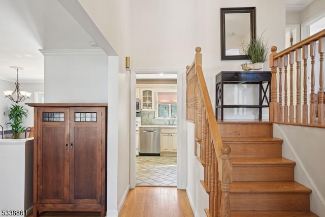 entrance foyer with a chandelier, light wood-type flooring, and stairs