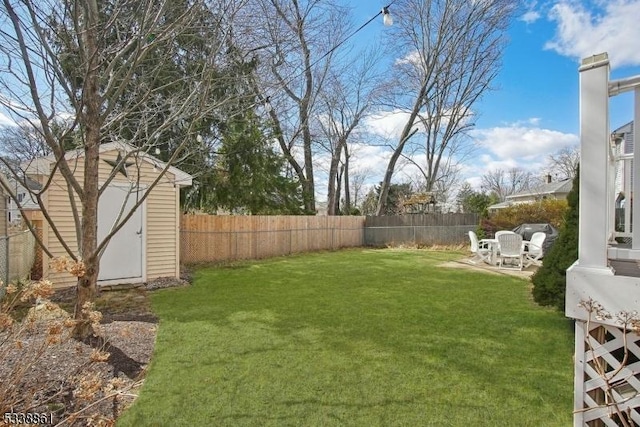 view of yard with an outbuilding, a fenced backyard, a patio, and a storage unit