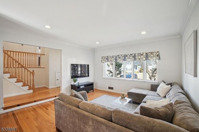 living room featuring light wood-style floors, recessed lighting, ornamental molding, and stairway