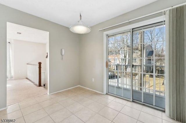 unfurnished room with light tile patterned flooring, light colored carpet, and baseboards