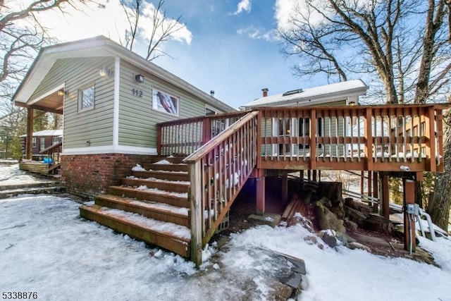 snow covered property featuring a wooden deck