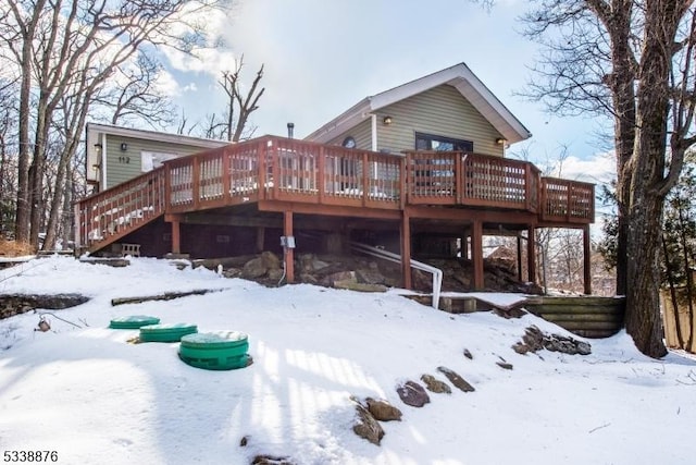 snow covered house with a wooden deck