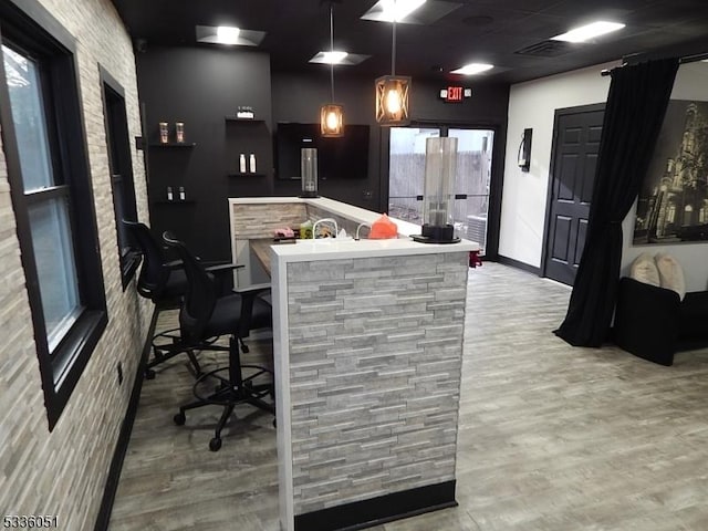 bar featuring decorative light fixtures, visible vents, baseboards, and wood finished floors