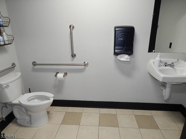 half bathroom with baseboards, toilet, and tile patterned floors