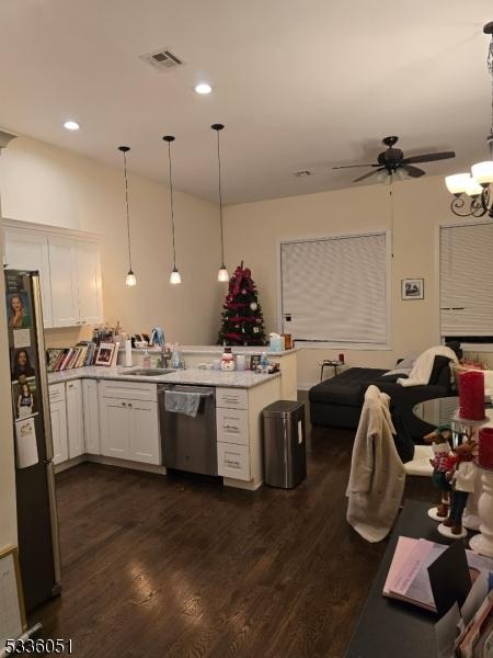 kitchen featuring decorative light fixtures, stainless steel appliances, light countertops, visible vents, and open floor plan