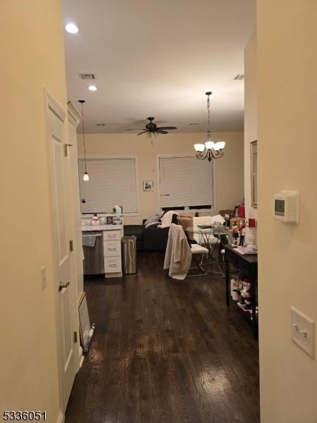 hallway featuring a notable chandelier, dark wood-type flooring, visible vents, and recessed lighting