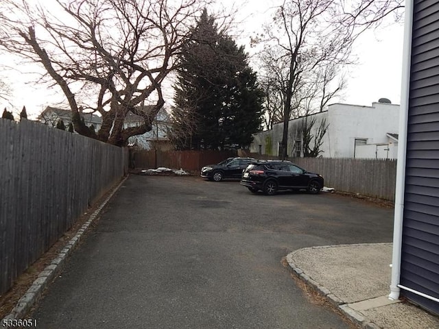 uncovered parking lot featuring fence