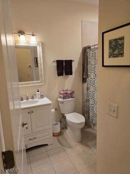 bathroom featuring tile patterned flooring, vanity, and toilet