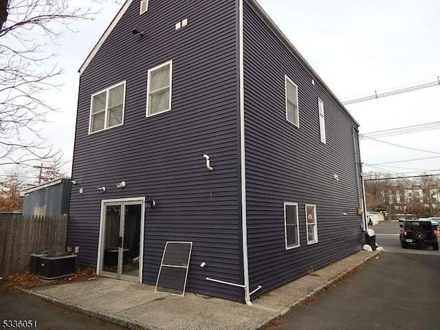 rear view of property featuring central AC, fence, and a patio