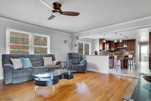 living room with ceiling fan, baseboards, light wood-style flooring, and crown molding