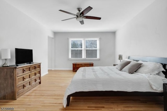 bedroom with light wood-type flooring, baseboards, and a ceiling fan