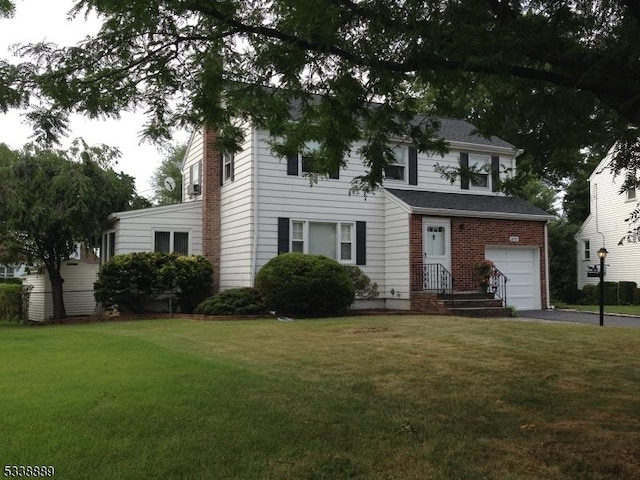 colonial inspired home with a front lawn and a garage