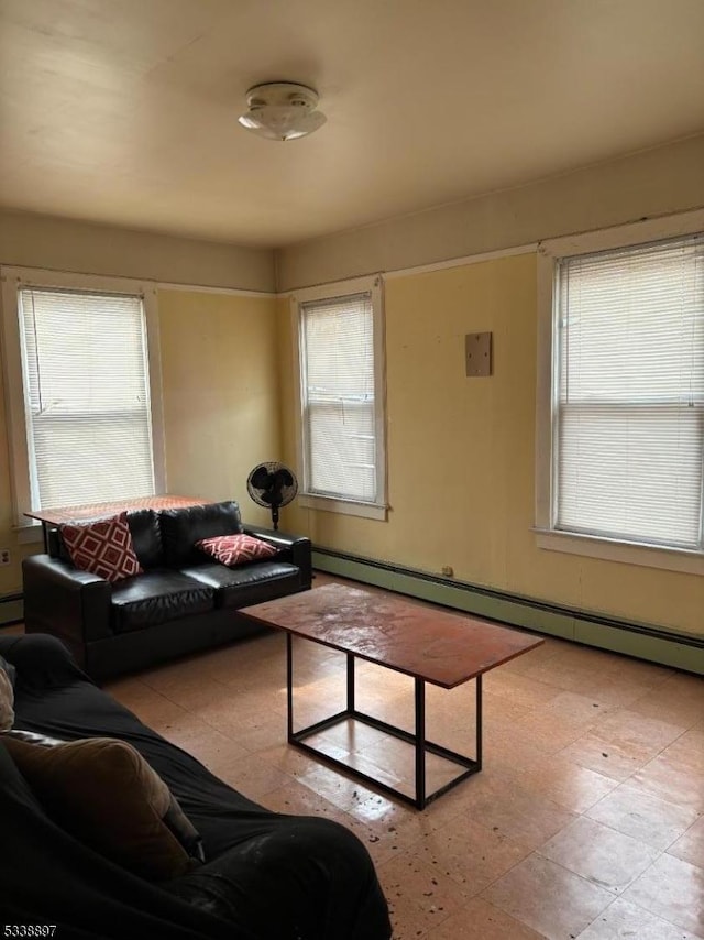 living room with light floors, a wealth of natural light, and baseboard heating