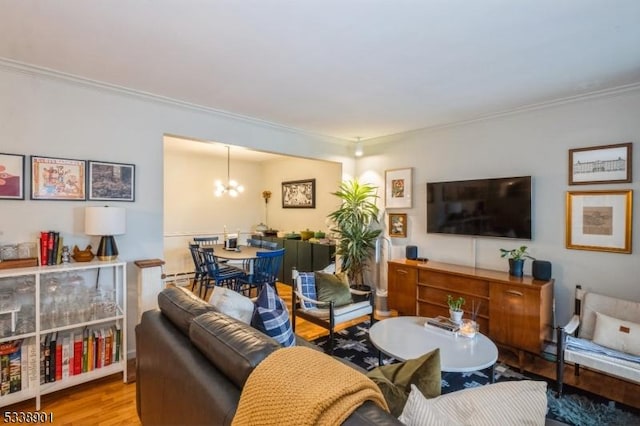 living area with crown molding, wood finished floors, and an inviting chandelier