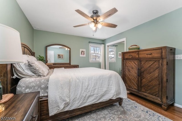 bedroom with ceiling fan and dark wood-type flooring