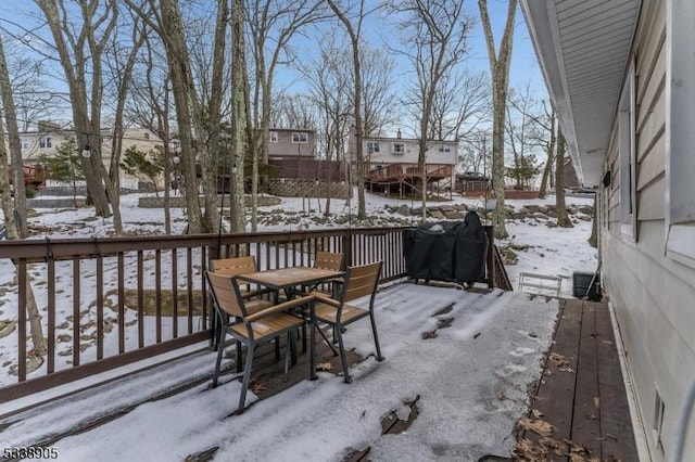 snow covered deck with a grill