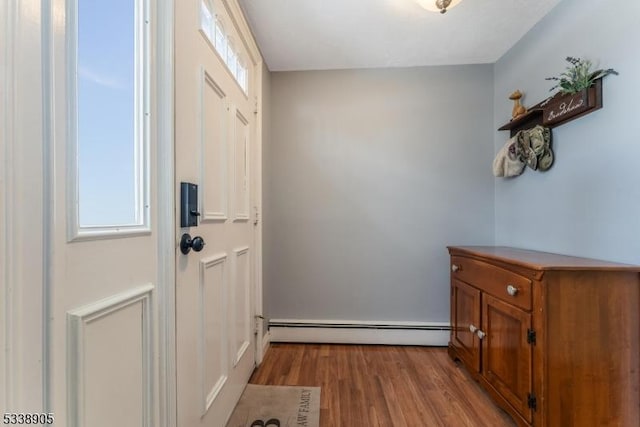 doorway featuring a baseboard heating unit and light wood-type flooring