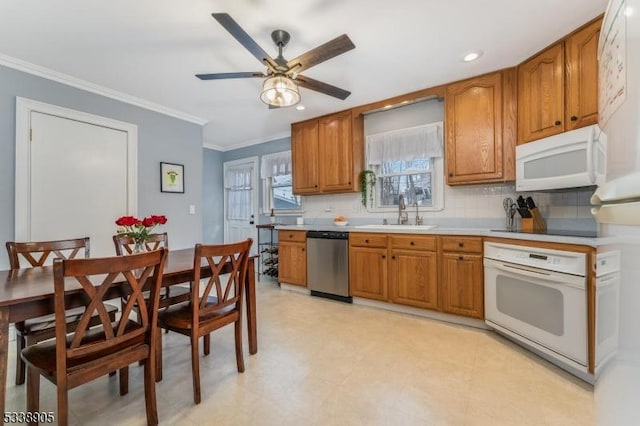 kitchen featuring sink, ornamental molding, white appliances, backsplash, and ceiling fan