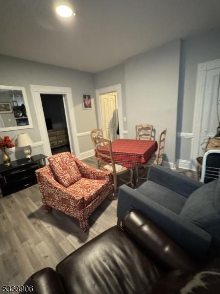 living area with baseboards and wood finished floors