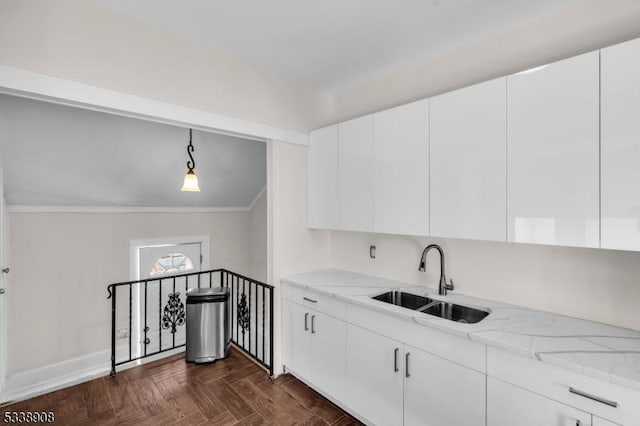 kitchen featuring sink, light stone counters, pendant lighting, dark parquet floors, and white cabinets