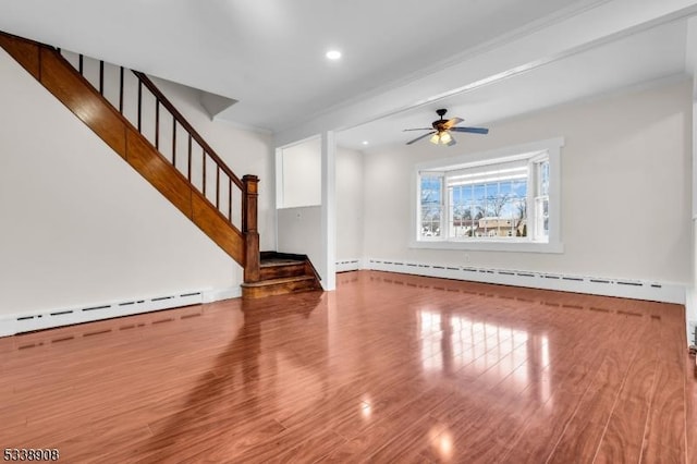 unfurnished living room with ceiling fan, wood-type flooring, a baseboard heating unit, and crown molding