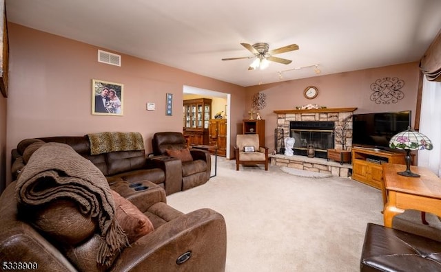 living room featuring ceiling fan, carpet floors, and a fireplace