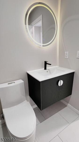 bathroom featuring vanity, tile patterned flooring, and toilet