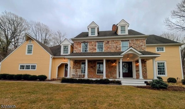 view of front facade featuring stone siding and a front yard