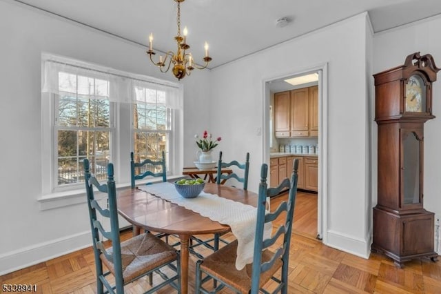 dining space with light parquet flooring and a notable chandelier