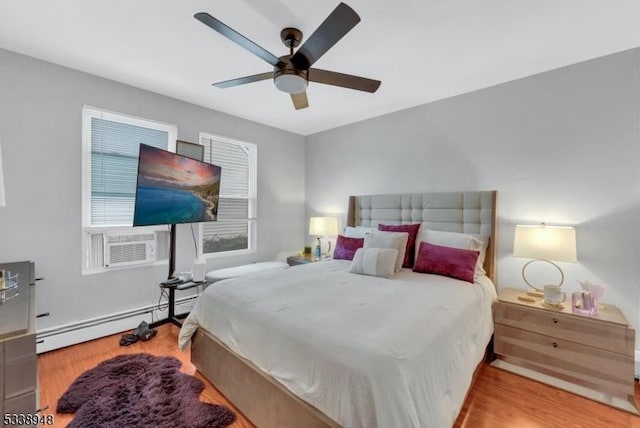 bedroom with ceiling fan, light wood-type flooring, cooling unit, and a baseboard heating unit