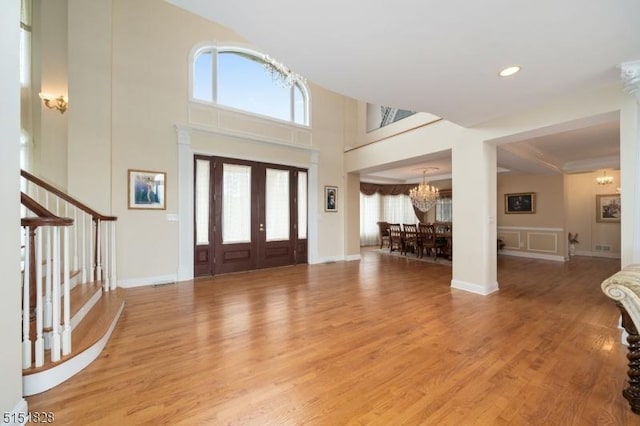 entrance foyer with light wood-style floors, a wealth of natural light, and a notable chandelier