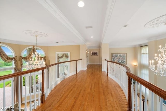 corridor featuring a chandelier, recessed lighting, baseboards, light wood finished floors, and crown molding