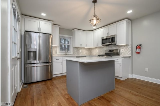 kitchen with stainless steel appliances, light countertops, and white cabinets