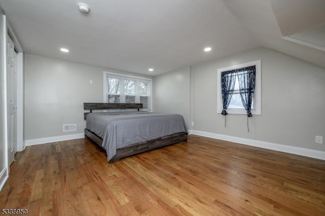 bedroom with recessed lighting, wood finished floors, visible vents, and baseboards