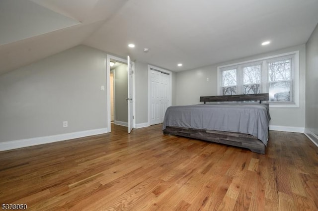 bedroom featuring vaulted ceiling, recessed lighting, light wood-type flooring, and baseboards