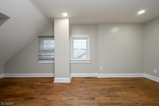 bonus room featuring lofted ceiling, baseboards, wood finished floors, and recessed lighting