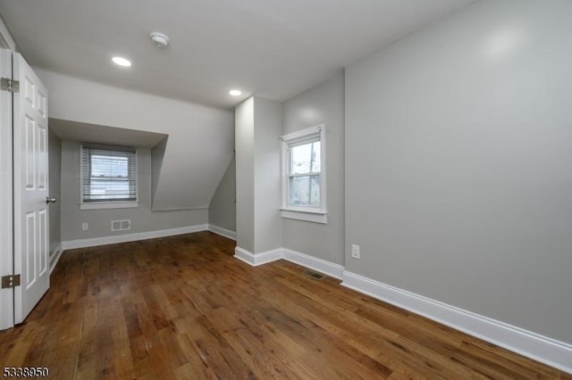 bonus room with a healthy amount of sunlight, baseboards, and dark wood-style flooring