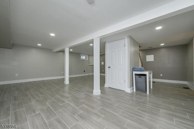 finished basement featuring baseboards, light wood finished floors, stairway, and recessed lighting