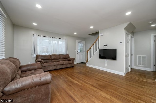 living area with stairway, visible vents, wood finished floors, and recessed lighting