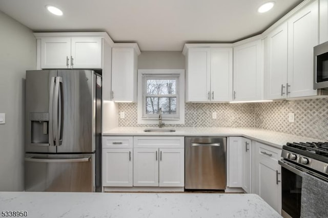 kitchen featuring stainless steel appliances, a sink, and white cabinets