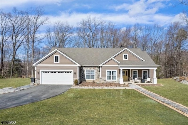 craftsman inspired home featuring stone siding, a chimney, aphalt driveway, a front lawn, and a porch