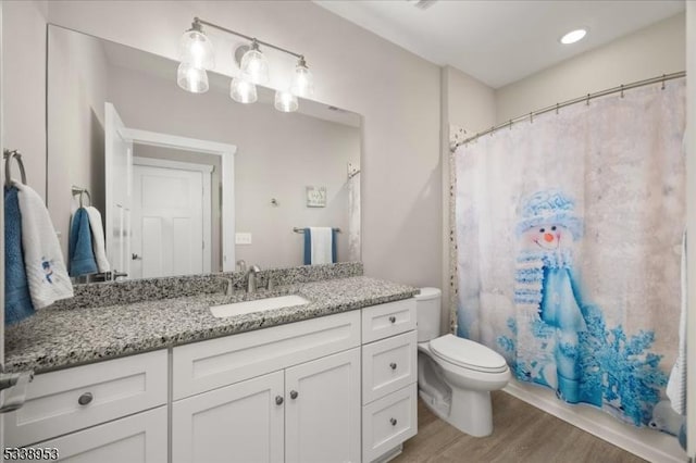 bathroom with a shower with curtain, vanity, toilet, and wood finished floors