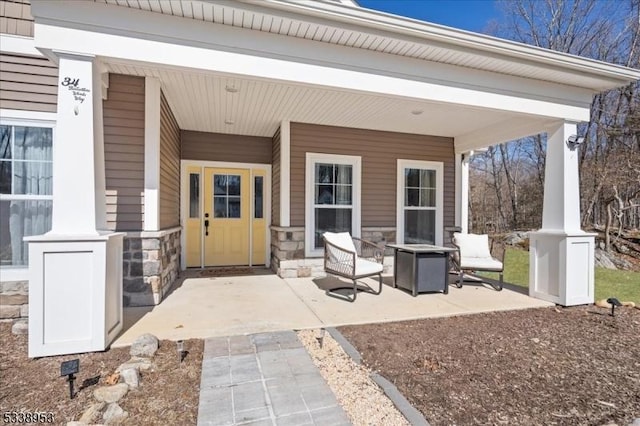 entrance to property featuring stone siding and a porch