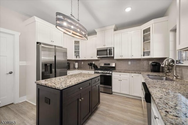 kitchen with appliances with stainless steel finishes, white cabinets, and a sink