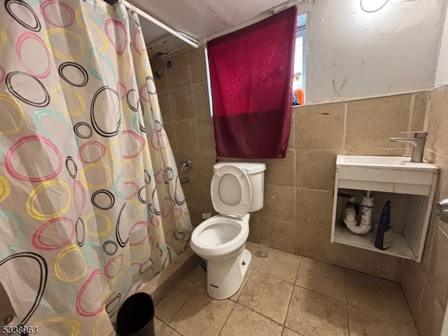 bathroom featuring tile patterned floors, sink, toilet, tile walls, and walk in shower