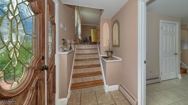 stairs featuring a baseboard radiator, baseboards, and tile patterned flooring