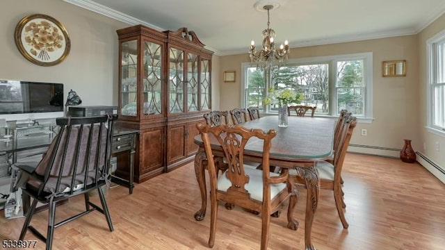 dining area featuring a notable chandelier, baseboard heating, ornamental molding, and light wood finished floors