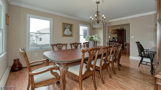 dining area featuring light wood-style flooring, crown molding, and a baseboard radiator