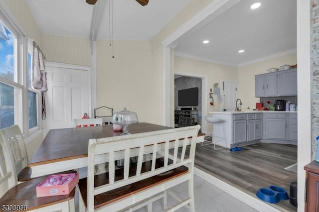 dining area with ceiling fan, ornamental molding, sink, and hardwood / wood-style floors