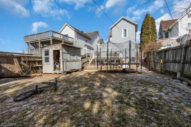 rear view of property featuring a storage unit and a trampoline